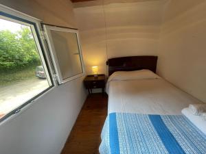 two beds in a small room with a window at La Casina de Castiello in Castiello