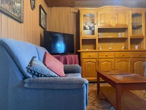 a living room with a blue couch and a table at La Casina de Castiello in Castiello
