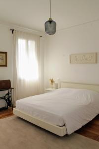 a white bedroom with a white bed and a window at Casa Dimatore in Dolo