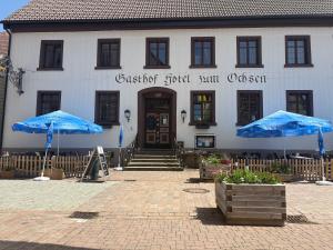 a building with blue umbrellas in front of it at Hotel Gasthof Zum Ochsen in Furtwangen