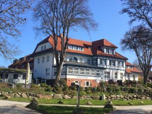 a large white building with a red roof at Ferienwohnung auf Hiddensee im Ort Kloster in Kloster