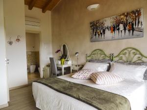 a bedroom with a large bed with a painting on the wall at B&B IL RICCIO in Costermano