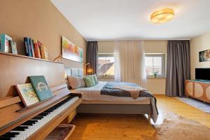 a bedroom with a bed and a piano at Gasthof Bräuhaus Lepple Apartments in Vöhringen
