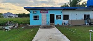 una casa azul y blanca con un patio de césped en SP 6 HOMESTAY KURANJI KOTA MARUDU, SABAH, Malaysia, 