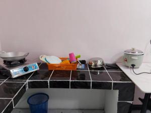 una encimera de cocina con tazones y utensilios. en SP 6 HOMESTAY KURANJI KOTA MARUDU, SABAH, Malaysia, 