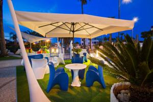 a table and chairs under a white umbrella at Hotel Ambassador in Grottammare