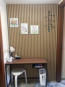 a desk with a chair next to a striped wall at Tucano studio apartment in Rho