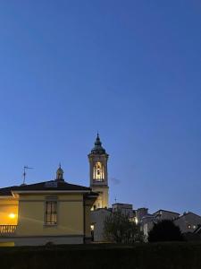 a building with a clock tower at night at Tucano studio apartment in Rho