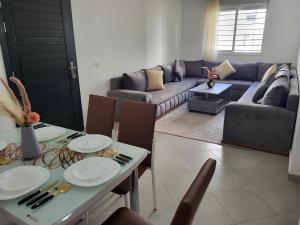 a living room with a table and a couch at Cosy Apartment Near Beach & Airport in Tangier