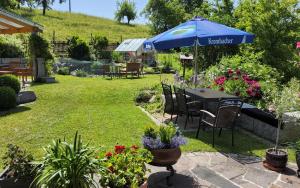 a table with an umbrella in a garden at Ferienhaus Hombergshalden in Geisingen