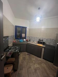 エッサウィラにあるAppartment couple moderneのコンロとカウンタートップのあるキッチン +2枚の写真