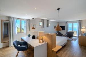 a bedroom with a bed and a desk in a room at Hôtel La Villa Douce in Rayol-Canadel-sur-Mer