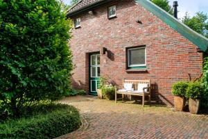 a brick house with a bench in front of it at Ferienhaus Neudorf in Varel