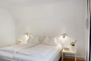 a white bed with white sheets and pillows at Ferienhaus Neudorf in Varel