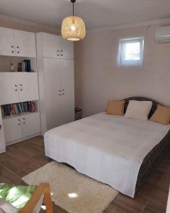 Un dormitorio con una gran cama blanca y una lámpara de araña. en Three-Bedroom Apartment in Balatonlelle I, en Balatonlelle