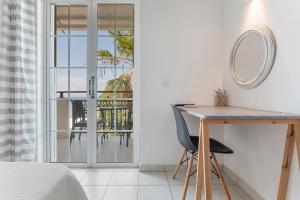 ein Schlafzimmer mit Schreibtisch und Blick auf eine Terrasse in der Unterkunft Bel Momento - Family Room in Alikanas