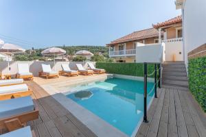 ein Swimmingpool mit Liegestühlen auf der Terrasse eines Hauses in der Unterkunft Bel Momento - Family Room in Alikanas