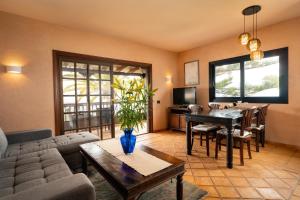 ein Wohnzimmer mit einer Couch und einem Tisch in der Unterkunft El Refugio Apartments & Villa in La Matanza de Acentejo