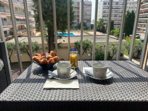 a table with a breakfast of coffee and pastries on a balcony at Les Caroubiers in Roquebrune-Cap-Martin