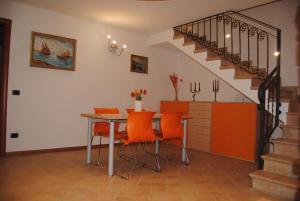 een eetkamer met een tafel en oranje stoelen bij Antea Nuevo Sol B&B in San Pellegrino Terme