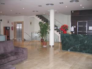 uma sala de estar com um sofá e uma escada em Hotel SG em Bullas