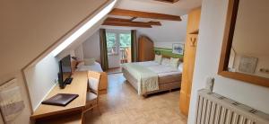 a room with a bed and a desk in a room at Gasthof Thomann in Velden am Wörthersee