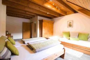 2 Betten in einem großen Zimmer mit Holzdecken in der Unterkunft Kempfenhof in Seelbach