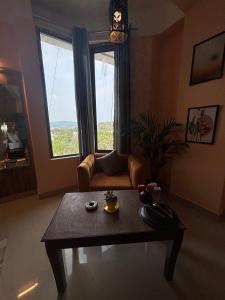 a living room with a table and a couch and a window at Casa Felice Stays in Guwahati