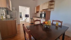 a kitchen with a table with a bowl of fruit on it at Ivory Apartment in Biograd na Moru