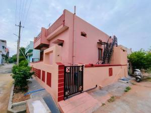 una casa rosa con una puerta negra en una calle en Backpacking hampi, en Hampi