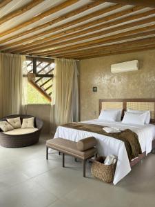 a bedroom with a large bed and a chair at Refúgio Tangará in Rio Acima +37 photos