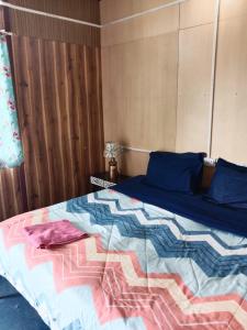 a bedroom with a bed with a colorful comforter at Corn Village Cottage in Lakhwār