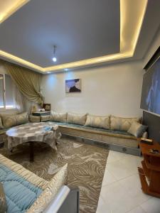 uma sala de estar com um sofá e uma TV em Hay el mohamadi agadir em Agadir