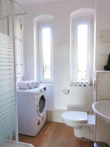a bathroom with a washing machine and a toilet at Modern 2BR apartment with 55" Smart TV & DeLonghi coffee machine in Magdeburg +8 photos