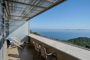 a balcony with chairs and a view of the ocean at Hôtel La Villa Douce in Rayol-Canadel-sur-Mer