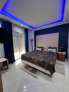 um quarto com uma cama com teto azul em Hay el mohamadi agadir em Agadir