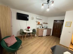 een woonkamer met een tafel en stoelen en een keuken bij Candy-Bombon Sibiu in Sibiu