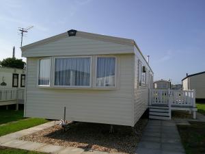 a tiny house is parked in a yard at Kingfisher New Horizon Firs 8 Berth Blow Heated in Ingoldmells