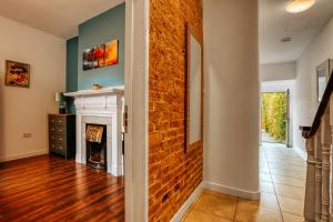 a living room with a brick wall and a fireplace at Open Mind Property - 4 Bedroom House with Hot Tub in Weston-super-Mare +25 photos