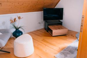 a living room with a television and a table at Ferienwohnung Alte Schneiderei in Heideck