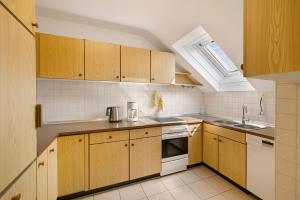 a kitchen with wooden cabinets and a sink and a window at Urlaub in der Sonnenstadt 72351 in Geislingen