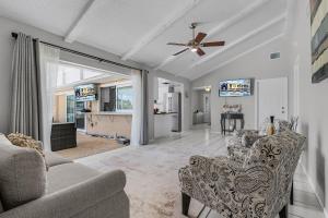 Una sala de estar con un sofá y un ventilador de techo. en Charming Retreat with Paddleboards for Adventure - Much Ado About Sunshine - Roelens, en Cabo Coral