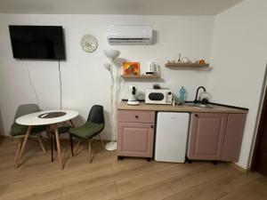 een keuken met een wastafel, een tafel en een koelkast bij Candy-Bombon Sibiu in Sibiu