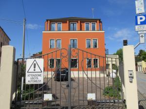 un edificio naranja con una puerta delante de él en Train Station Apartments, en Marghera