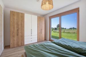 a bedroom with a bed and a large window at Ferienwohnung Alpenliebe in Höchenschwand