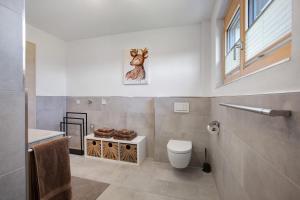 a bathroom with a toilet and a picture of a deer at Ferienwohnung Alpenliebe in Höchenschwand +18 photos
