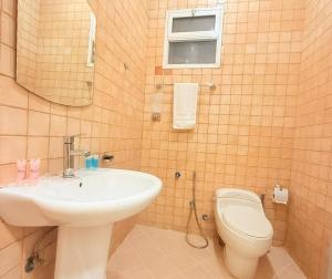 a bathroom with a sink and a toilet and a mirror at توارن عنيزة in Riyadh