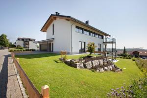a white house with a stone wall in front of it at Ferienwohnung Alpenliebe in Höchenschwand