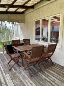 a wooden table and chairs on a deck at Hus på bondgård in Gunnarskog