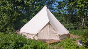 a large white tent in a field with trees at Bell-tent Noord in Lappeenranta